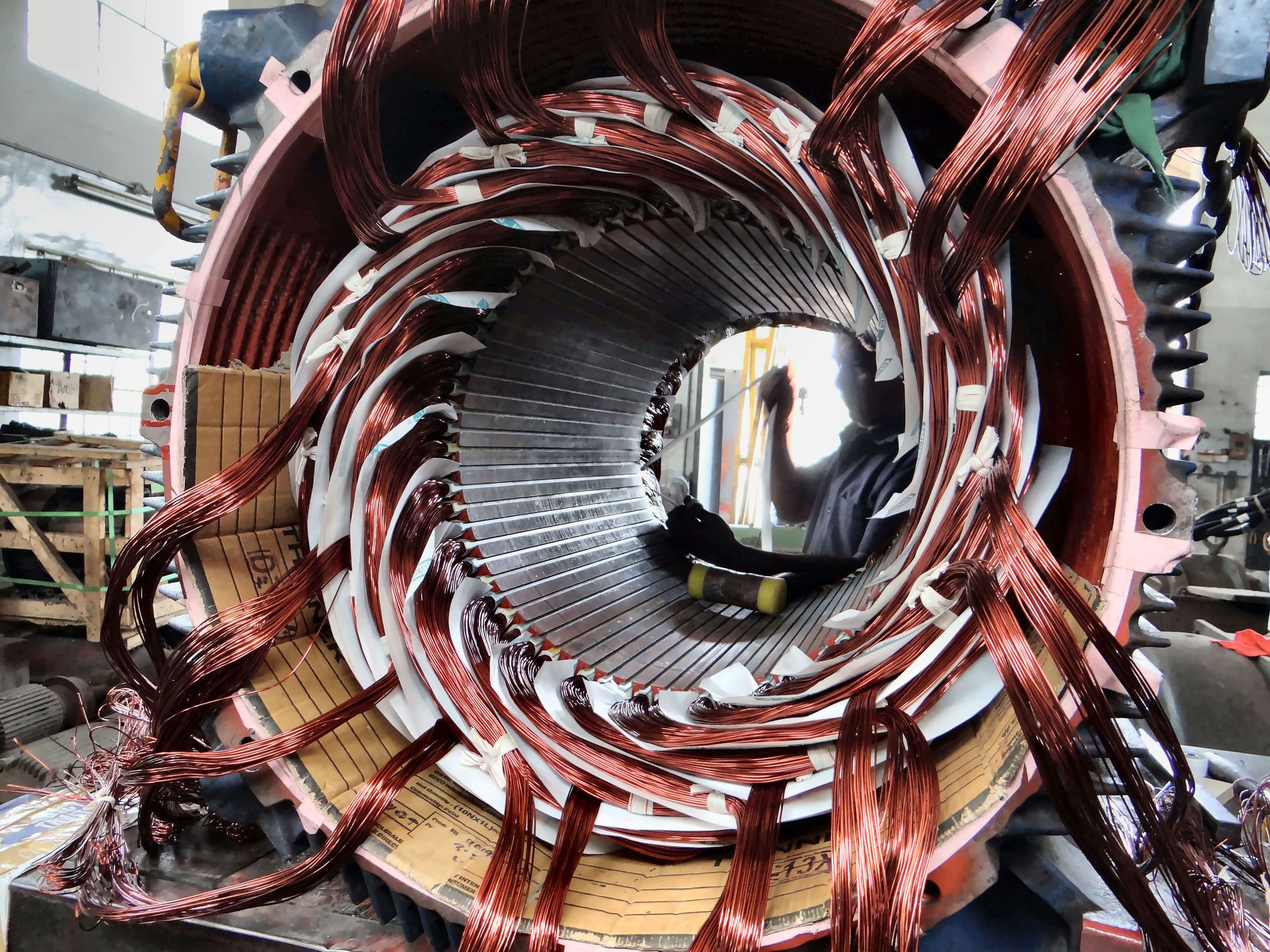Technicians rewinding a large stator on the shop floor